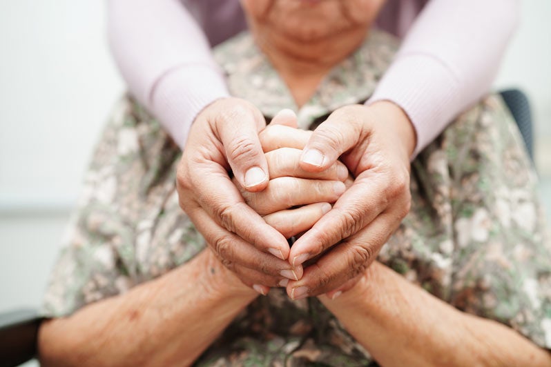 Caregiver holding hands Asian elderly woman patient